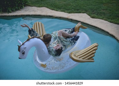 Woman In A Long Dress On The Inflatable Pegasus In The Pool (with Extra Grain, Old Photo Effect)
