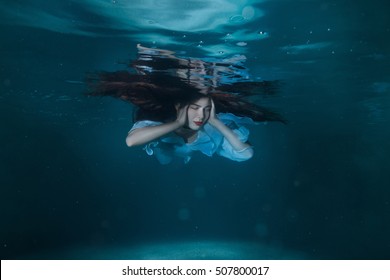 Woman With Long Hair Floating In The Water.