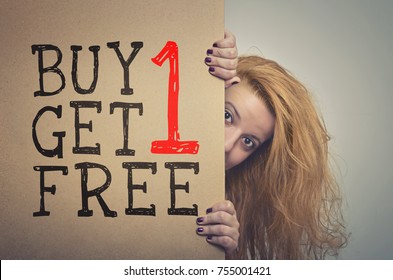 Woman with long hair peeking behind a Buy 1 Get 1 Free billboard poster. 