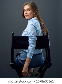 Woman With Long Hair  Sitting Back On Movies Director Chair Turns To  Side. Isolated Female Profile Portrait.