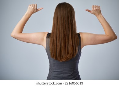 Woman With Long Hair Standing Back And Showing Thumbs Up With Raised Hands, Portrait On Gray Isolated Background.