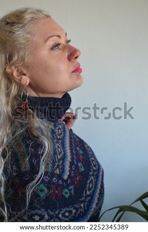 Woman  long silver hair braids in winter sweater blond Nordic woman looking away white background natural real woman long silver hair dreamy portrait