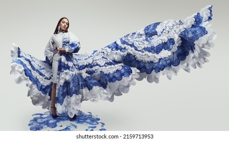 Woman in long woderful flying dress with blue and white waves. Drawing and ruffles on clothes    
