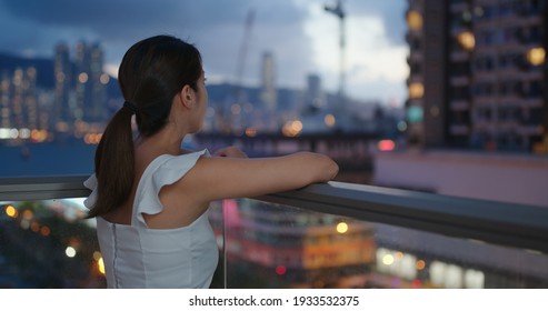 Woman Look At The City From Balcony At Night