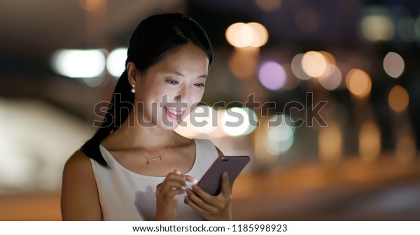 Woman look at mobile\
phone in the evening