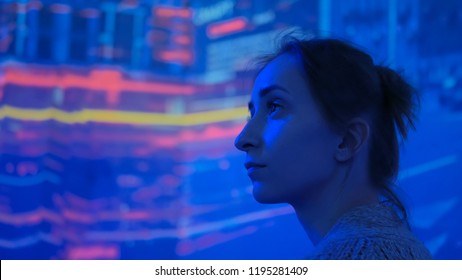 Woman Looking Around And Watching Video Presentation On Large Display Wall At Futuristic Technology Exhibition