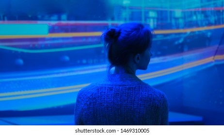 Woman Looking Around And Watching Video Presentation On Large Display Wall At Futuristic Technology Exhibition