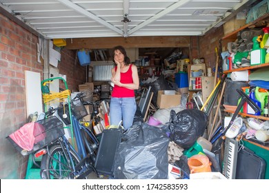 Woman looking bemused about where to start in clearing out her garage - Shutterstock ID 1742583593