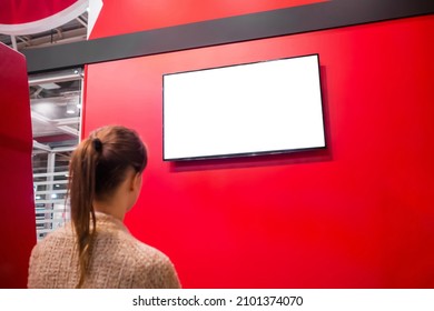 Woman Looking At Blank Digital Interactive White Display On Red Wall At Exhibition Or Museum With Futuristic Scifi Interior. White Screen, Mock Up, Copyspace, Template, Technology Concept