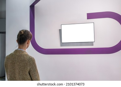 Woman Looking At Blank Digital Interactive White Display Wall At Exhibition Or Museum With Futuristic Scifi Interior. White Screen, Mock Up, Future, Copyspace, Template, Technology Concept