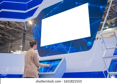 Woman Looking At Blank Large Wide Interactive Wall White Display At Modern Technology Exhibition Or Museum With Futuristic Sci-fi Interior. Mock Up, White Screen, Template, Education, Isolated Concept