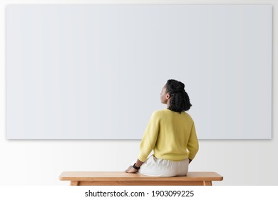Woman looking at blank wall rear view