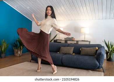 Woman Looking At Camera Dancing Energetically At Home