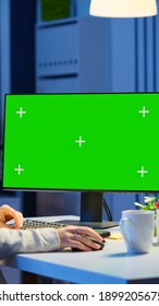 Woman looking at computer with chroma key during night time in start up business office working overtime. Freelancer watching desktop monitor mockup display with green screen, typing writting - Shutterstock ID 1899205675