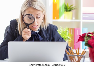 Woman Looking At Computer Screen Through A Magnifying Glass