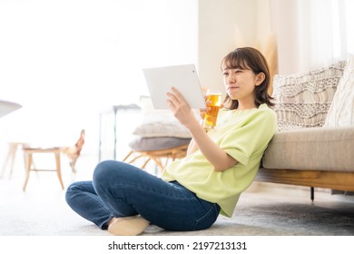 Woman Looking At Computer While Drinking Beer