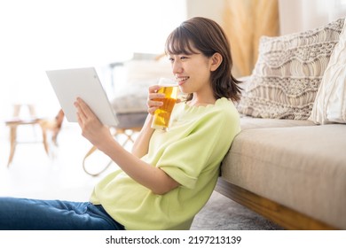 Woman Looking At Computer While Drinking Beer