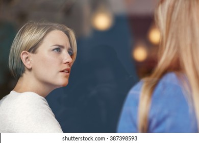 Woman looking concerned while listening carefully to her friend - Powered by Shutterstock