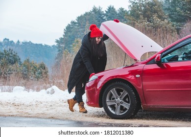 Woman Looking At Engine Broken Car At Winter Road Side