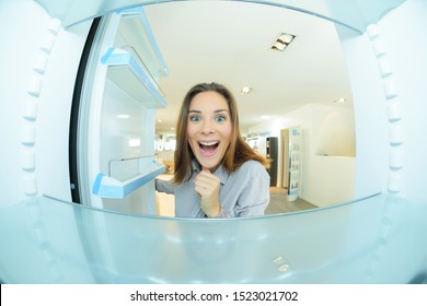 Woman Looking Excitedly Into Empty Fridge