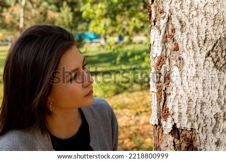 Woman looking at firebugs on the tree bark