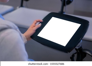 Woman looking at floor standing tablet kiosk with blank white display at exhibition or museum - close up view. Mock up, futuristic, copyspace, template, isolated, white screen, technology concept