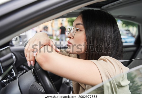 Woman looking forward and relaxing at the steering\
wheel before the riding