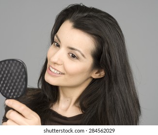 Woman Looking In Hand Held Mirror