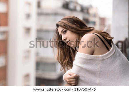 Woman looking from her balcony the city