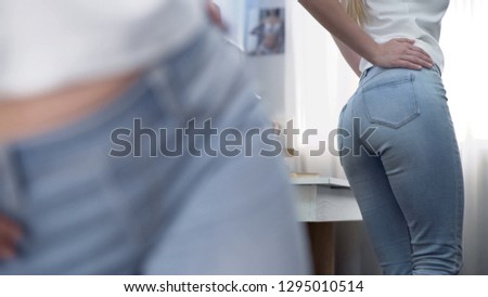 Woman looking at her body reflection in mirror, backside posing, fitness result
