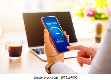 Woman looking at her credit score result on mobile phone - Shutterstock ID 1978169000