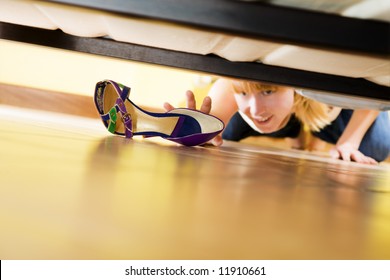 Woman Looking For Her Shoe Under The Bed