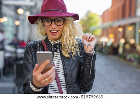 Woman looking at her smartphone in pleasant surprise