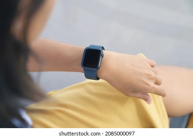 A woman looking at her smartwatch on hand