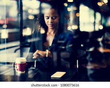 Woman Looking At Her Watch At Cafe