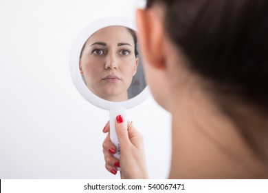 Woman Looking At Herself In The Mirror
