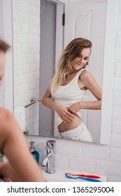 Woman Looking At Himself In Front The Mirror And Showing Stomach At Bathroom