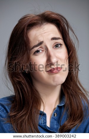 Woman is looking imploring over gray background