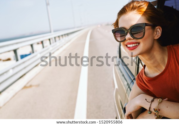 woman looking into the distance in the car with\
glasses with a beautiful\
smile