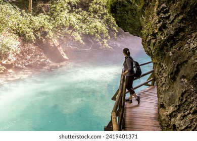 Woman looking into the water on the wooden path in the Vintgar Gorge in Slovenia. - Powered by Shutterstock