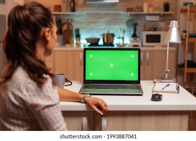 Woman Looking At Laptop With Green Mockup During Night Time In Home Kitchen. Sitting At Desk Works On Computer Late At Night, Business, Online, Smart, Blank, Copyspace.