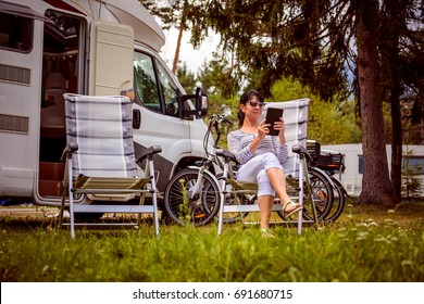 Woman looking at the laptop near the camping . Caravan car Vacation. Family vacation travel, holiday trip in motorhome. Wi-fi connection information communication technology. - Powered by Shutterstock