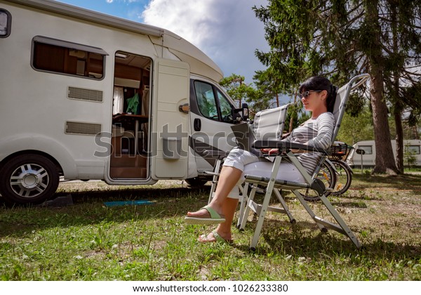 Woman\
looking at the laptop near the camping . Caravan car Vacation.\
Family vacation travel, holiday trip in motorhome RV. Wi-fi\
connection information communication\
technology.