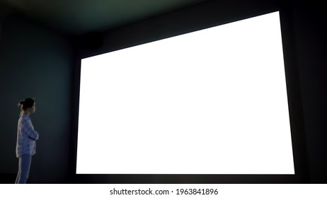 Woman Looking At Large Wall Blank Interactive White Display In Dark Room Of Modern Technology Exhibition Or Museum. Mock Up, White Screen, Futuristic, Template, Education Concept