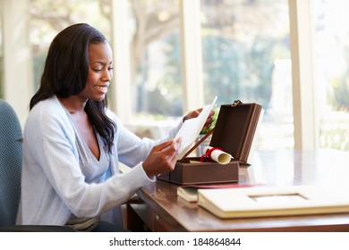 Woman Looking At Letter In Keepsake Box On Desk