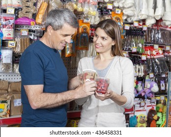 Woman Looking At Man While Choosing Pet Food In Store