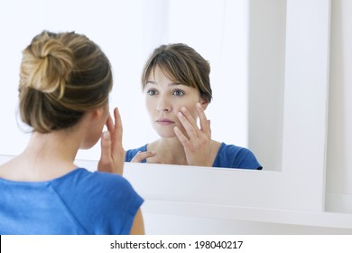 Woman Looking In A Mirror.