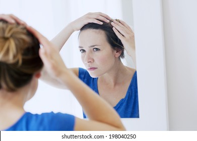 Woman Looking In A Mirror.