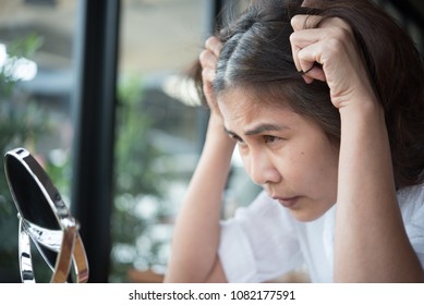 Woman Looking At Mirror And Worries  Gray Hair And Hair Loss Problem 