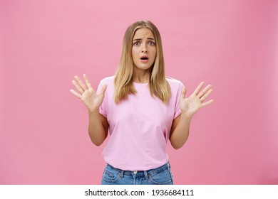 Woman Looking Nervous Explaining With Panicking Gestures She Not Involved Frowning Opening Mouth And Gasping Feeling Concerned And Worried Waving Hands Over Chest Posing Against Pink Wall